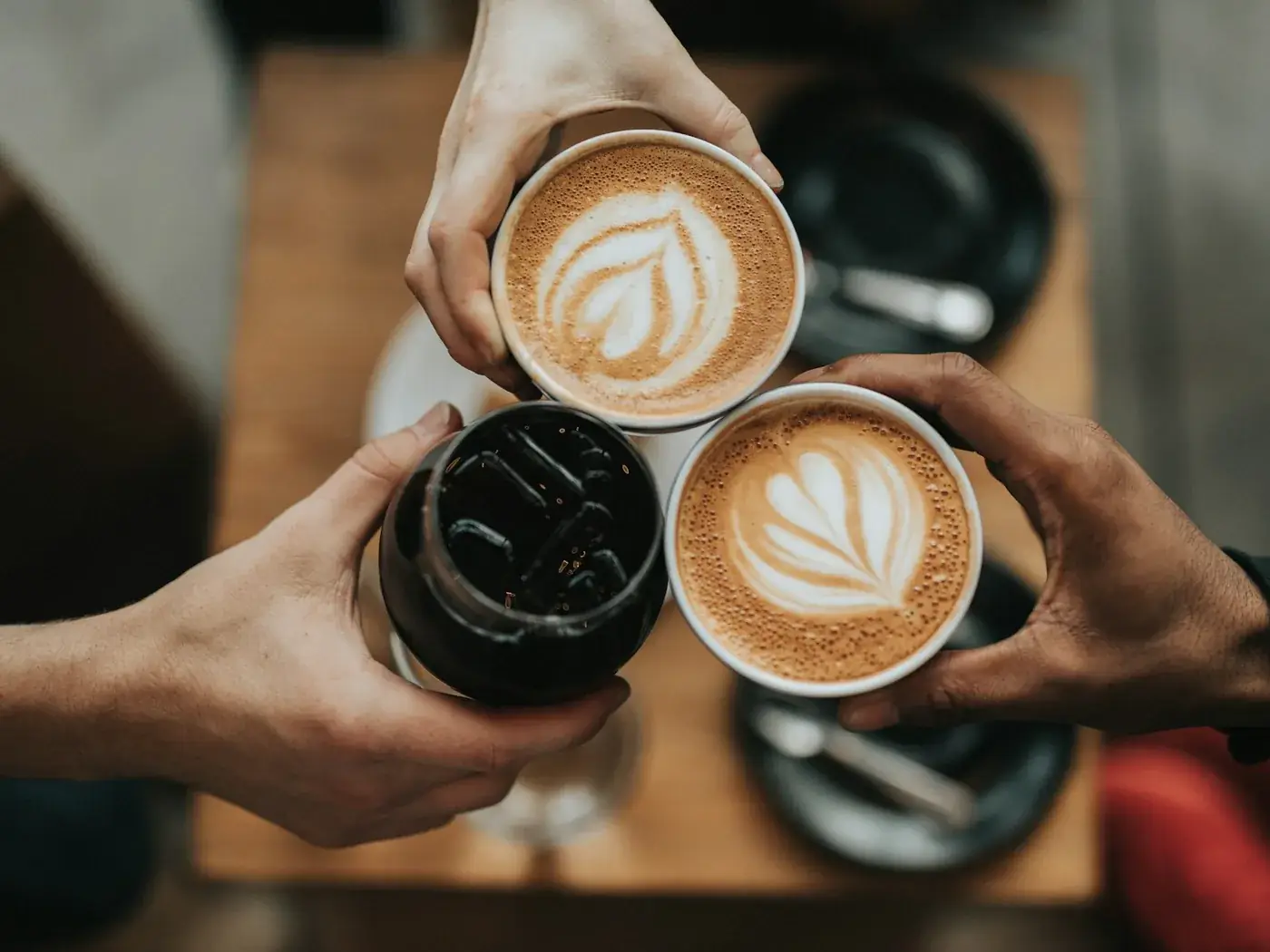 Three cups of coffee raised together